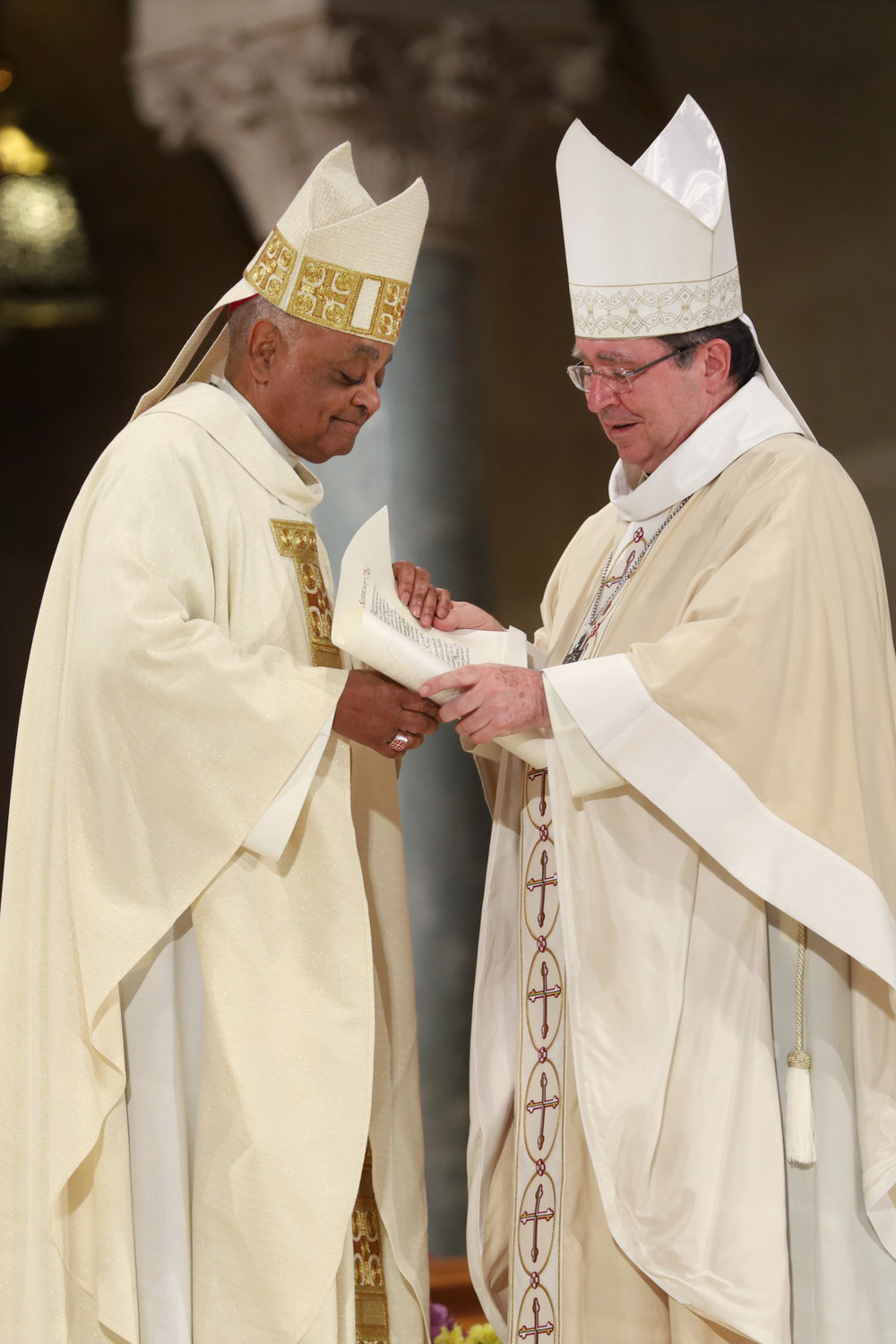 Archbishop Wilton D. Gregory receives the papal bull on his appointment to Washington from Archbishop Christophe Pierre, apostolic nuncio to the United States, during his installation Mass at the Basilica of the National Shrine of the Immaculate Conception in Washington May 21, 2019.